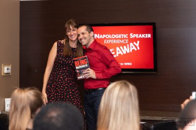 Unapologetic Speaker - laura and davide on stage 3 smiling with book
